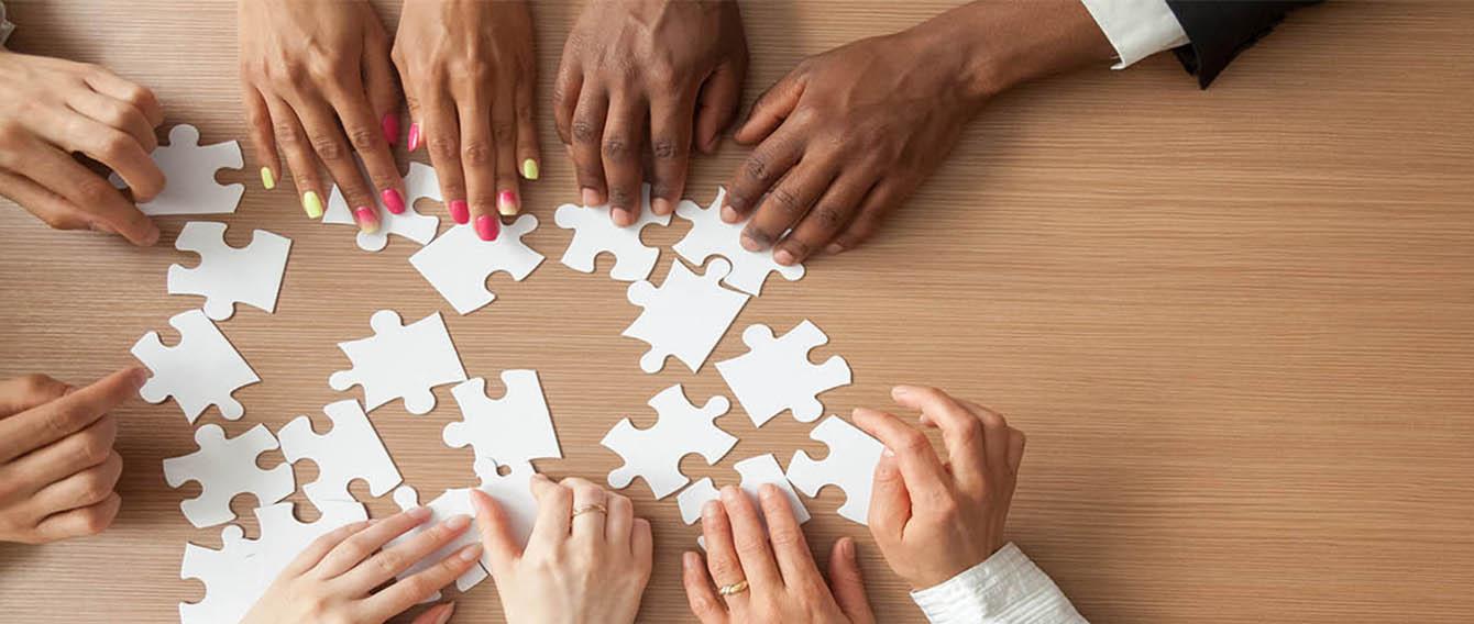 hands building a puzzle
